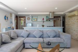 a living room with a couch and a glass table at Amazing Seaview Apartment in Ko Lanta +6 photos