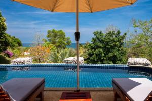 an umbrella sitting next to a swimming pool at Amazing Seaview Apartment in Ko Lanta