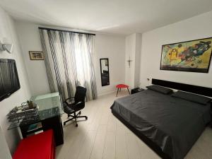 a bedroom with a bed and a desk and a chair at AragonApartment in Santa Maria a Vico