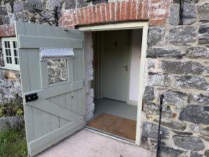 a door leading into a brick building with a garage at Drewe Arms Bunk Rooms in Drewsteignton +4 photos