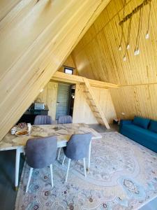 a dining room with a table and chairs in a attic at Kolsay A-Frame Yessen in Saty