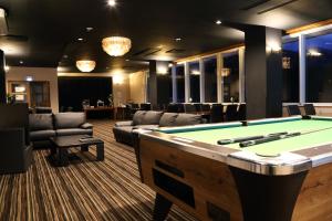 a billiard room with a pool table and couches at Hakuba Echo Hotel and Apartments in Hakuba