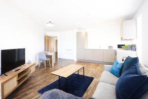 a living room with a couch and a table at Comfortable modern apartment near Bicester in Bicester