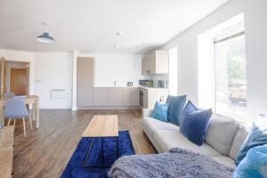 a living room with a couch and a table at Comfortable modern apartment near Bicester in Bicester