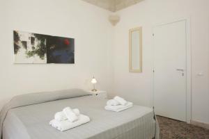 a white bedroom with a bed with towels on it at B&b Il Tufo in Favignana