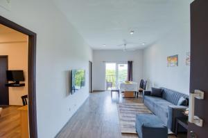 a living room with a blue couch and a table at Iyla Apart Hotel in Pondicherry
