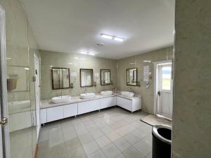 a bathroom with three sinks and two mirrors at Maikhan Tolgoi lodge in Horgo +36 photos