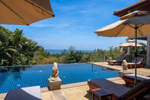 a swimming pool with chairs and umbrellas in a resort at 2 Pools And Seaview! Villa Serena 6Br, Klong Khong in Ko Lanta