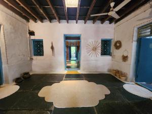 an empty room with a large rug on the floor at Peshagar Guest House in Hampi