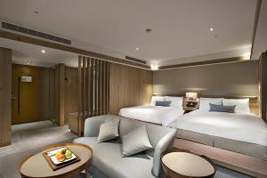 a hotel room with two beds and a couch at Hotel Royal Chihpin in Wenquan