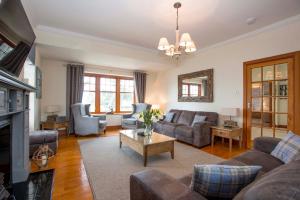 sala de estar con sofás y chimenea en Sea View Lodge, en Nairn