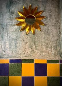 a sun decoration on a wall with colorful tiles at Extraordinaire face aux Arènes in Arles