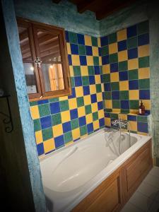 a bath tub in a bathroom with colorful tiles at Extraordinaire face aux Arènes in Arles