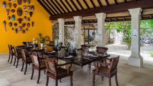 a dining room with a long table and chairs at Luxury Beachfront Villa in North Lombok in Gili Islands