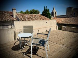 two chairs and a table on a rooftop deck at Extraordinaire face aux Arènes in Arles