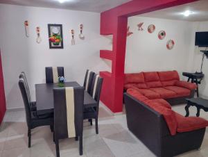 a dining room with a table and a red couch at Casa en la Palpa in Huauchinango