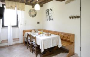a dining room with a table and a clock on the wall at 2 Bedroom Pet Friendly Apartment In Scansano in Scansano