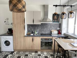 a kitchen with a sink and a washing machine at Les Bruyeres in Concarneau