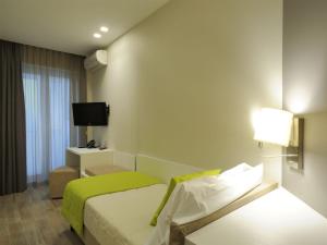 um quarto de hotel com uma cama e uma televisão em Hotel Concordia em Loano