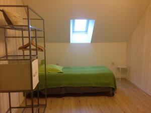 a bedroom with a green bed and a window at La Rosée D'Anché in Anché