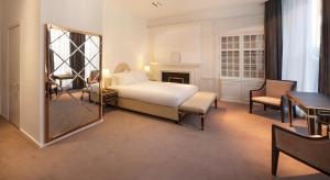 a bedroom with a bed and a chair and a mirror at Nottingham Place Hotel in London