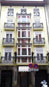 a tall yellow building with windows and balconies at Dato 2 in Vitoria-Gasteiz