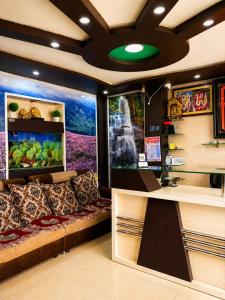 a room with a couch and a fish tank at manjunatha residency in Chikmagalūr +9 photos