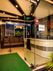 a lobby with a couch and a green rug at manjunatha residency in Chikmagalūr