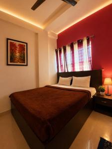 a bedroom with a large bed with a red wall at manjunatha residency in Chikmagalūr