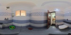 a bathroom with blue and white stripes on the walls at manjunatha residency in Chikmagalūr
