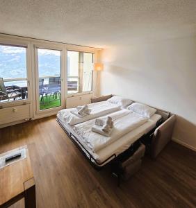 a large bed in a room with a balcony at Alpine Luxury Suite Beatenberg in Beatenberg +49 photos