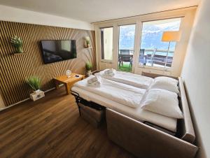 a bedroom with a large bed and a large window at Alpine Luxury Suite Beatenberg in Beatenberg