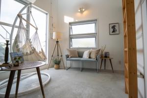 a living room with a couch and a hammock at Balmy Ocean OKINAWA in Yomitan