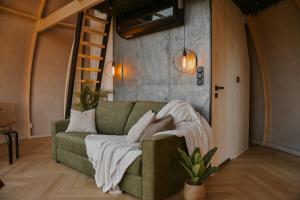 a living room with a green couch with pillows at AtmoSphere Czorsztyn in Czorsztyn