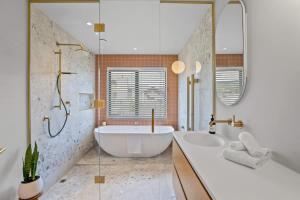 a bathroom with a tub and two sinks and a shower at Rua Street Escape in Wanaka