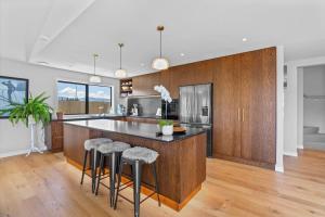 a kitchen with a large island with bar stools at Rua Street Escape in Wanaka