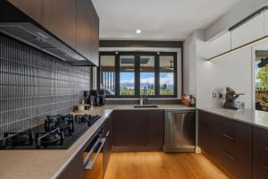 a kitchen with stainless steel appliances and a large window at Wanaka Mountain Oasis - Spa & Pool in Wanaka