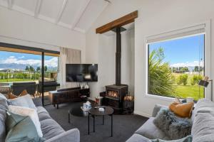a living room with a couch and a fireplace at Wanaka Mountain Oasis - Spa & Pool in Wanaka