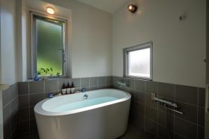 a bath tub in a bathroom with a window at Balmy Ocean OKINAWA in Yomitan