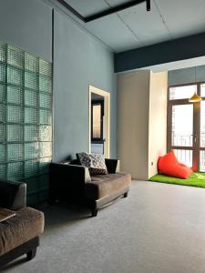 a living room with a couch and two windows at Smile Residence Bishkek in Bishkek
