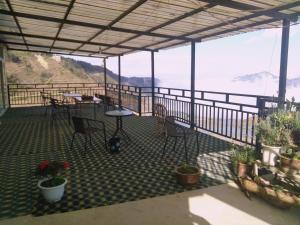a patio with tables and chairs and a view of the ocean at Jacky's Guesthouse in Yuanyang