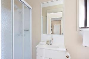 a white bathroom with a sink and a shower at Reflections Red Rock - Holiday Park in Red Rock +44 photos