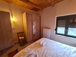 a bedroom with a large white bed and a window at Οκά & δράμι in Kaléntzion