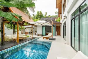 an external view of a villa with a swimming pool at Chalong Thai-Style Pool Villa in Phuket
