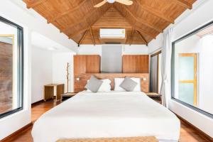 a bedroom with a large white bed with a ceiling at Chalong Thai-Style Pool Villa in Phuket +49 photos