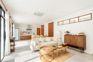 a living room with a white couch and a table at Chalong Thai-Style Pool Villa in Phuket