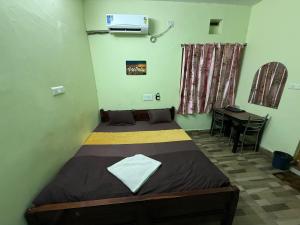 a bedroom with a bed and a table in a room at Sunlight Premium in Bhubaneshwar