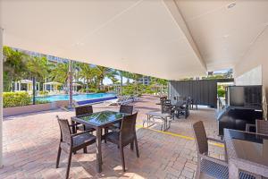 an outdoor patio with tables and chairs and a pool at Le Vent Eagle Beach Condos by Bocobay Aruba in Palm-Eagle Beach +25 photos