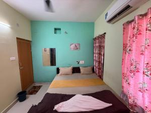 a bedroom with two beds and a blue wall at Sunlight Premium in Bhubaneshwar