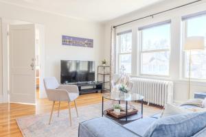 a living room with a couch and chairs and a tv at Brighton 2 bedroom in Boston